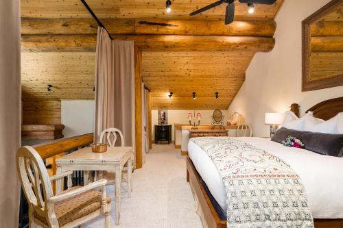 a bedroom with a bed and a table and a desk at Penthouse 4 by Moonlight Basin Lodging in Big Sky