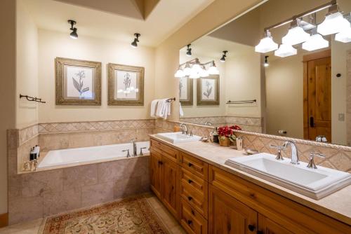 a bathroom with two sinks and a large mirror at Penthouse 4 by Moonlight Basin Lodging in Big Sky