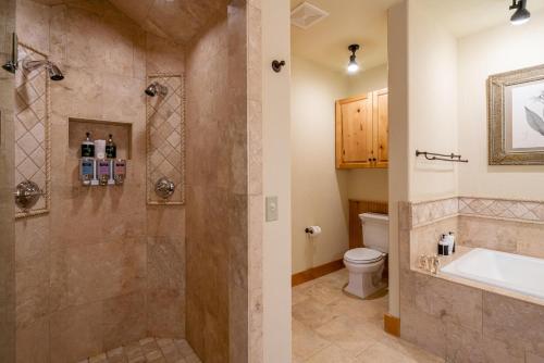 a bathroom with a shower and a toilet at Penthouse 4 by Moonlight Basin Lodging in Big Sky