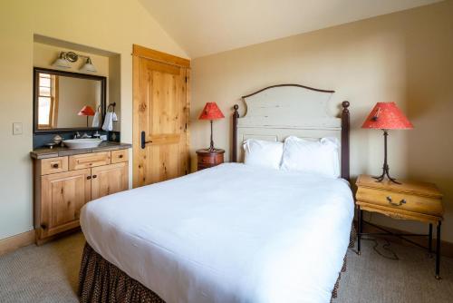 a bedroom with a large white bed and a sink at Penthouse 4 by Moonlight Basin Lodging in Big Sky