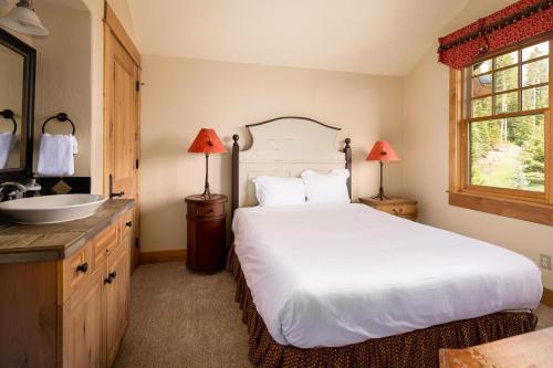 a bedroom with a large white bed and a sink at Penthouse 4 by Moonlight Basin Lodging in Big Sky