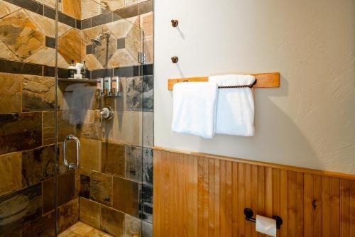 a bathroom with a shower and towels on a wall at Penthouse 4 by Moonlight Basin Lodging in Big Sky