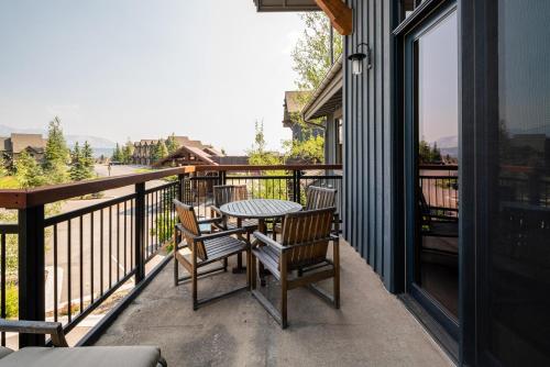 a patio with a table and chairs on a balcony at Penthouse 4 by Moonlight Basin Lodging in Big Sky