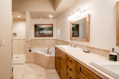 a bathroom with a tub and a sink and a bath tub at Penthouse 3 by Moonlight Basin Lodging in Big Sky
