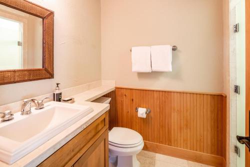 a bathroom with a sink and a toilet and a mirror at Penthouse 3 by Moonlight Basin Lodging in Big Sky