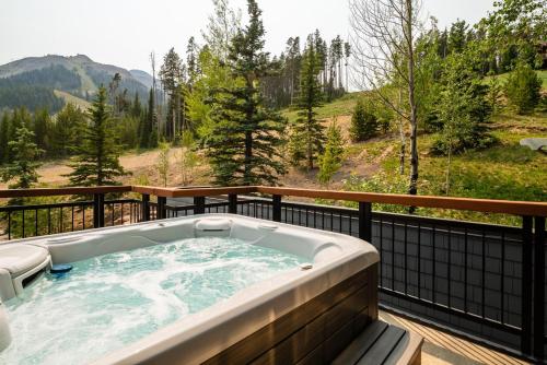 a jacuzzi tub on a deck with a view at Penthouse 3 by Moonlight Basin Lodging in Big Sky