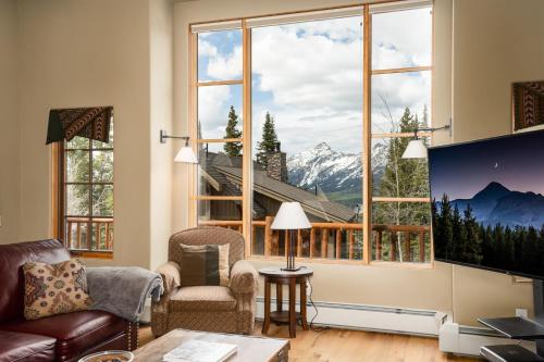 - un salon doté d'une grande fenêtre offrant une vue sur la montagne dans l'établissement 6 Mountain Home Road by Moonlight Basin Lodging, à Big Sky