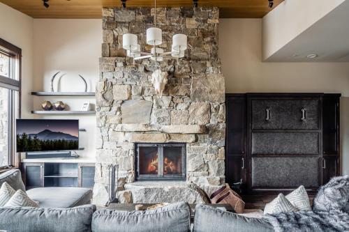 a living room with a stone fireplace at 4B Lodgeside by Moonlight Basin Lodging in Big Sky