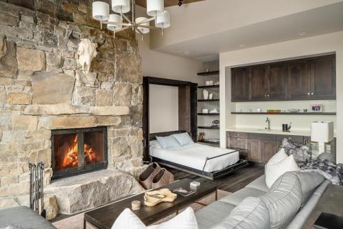 a living room with a large stone fireplace at 4B Lodgeside by Moonlight Basin Lodging in Big Sky