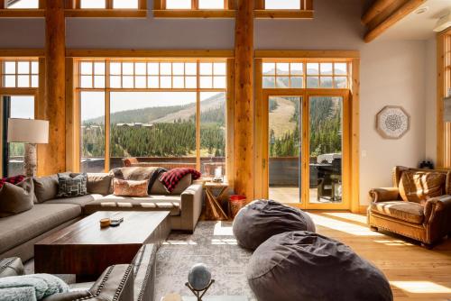 a living room filled with furniture and a large window at Penthouse 1 by Moonlight Basin Lodging in Big Sky