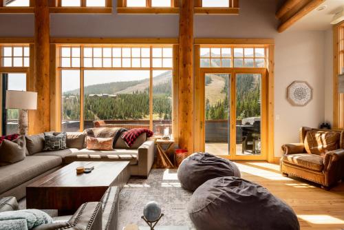 een woonkamer met meubilair en een groot raam bij Penthouse 1 by Moonlight Basin Lodging in Big Sky