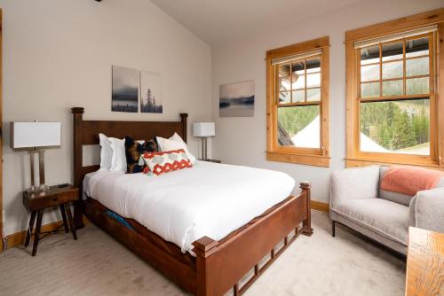 a bedroom with a bed and a couch and a chair at Penthouse 1 by Moonlight Basin Lodging in Big Sky