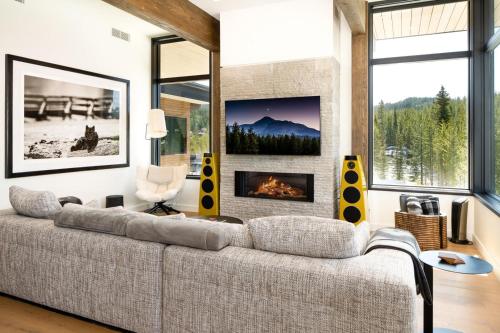een woonkamer met een bank en een open haard bij 232 LakeLodge by Moonlight Basin Lodging in Big Sky