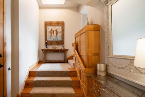 a hallway with stairs and a painting on the wall at Penthouse 1 by Moonlight Basin Lodging in Big Sky