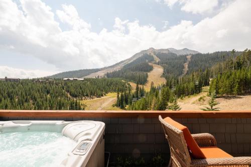 a hot tub on a balcony with a view of a mountain at Penthouse 1 by Moonlight Basin Lodging in Big Sky