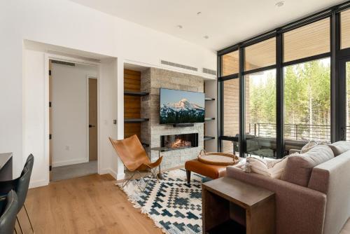 een woonkamer met een bank en een open haard bij 221 LakeLodge by Moonlight Basin Lodging in Big Sky