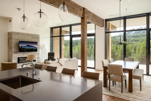 een keuken en woonkamer met een tafel en stoelen bij 212 LakeLodge by Moonlight Basin Lodging in Big Sky
