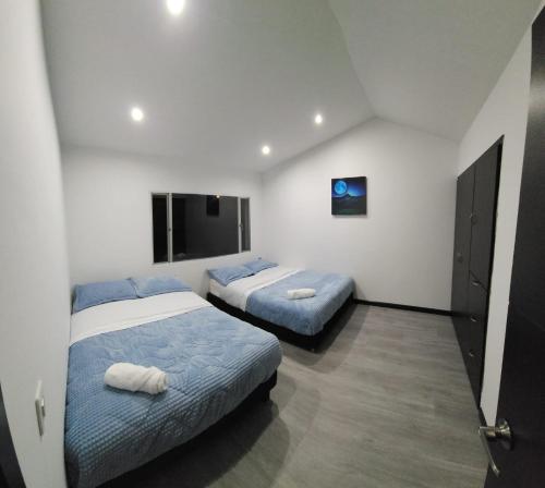 1 dormitorio con 2 camas y TV en Casa Chimenea a 5 minutos del Aeropuerto en Bogotá