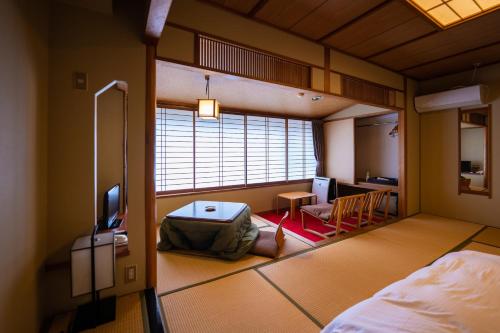 Sakahijiri Nikko في نيكو: غرفة مع غرفة نوم مع سرير ومكتب