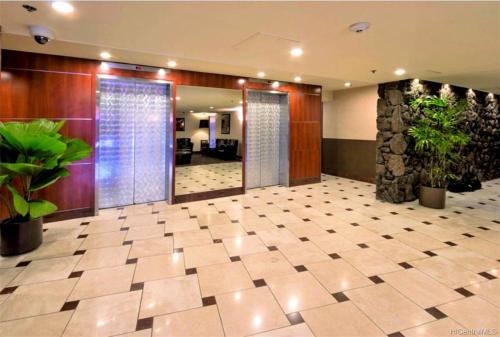 a lobby with potted plants in a building at Marine Surf Waikiki in Honolulu