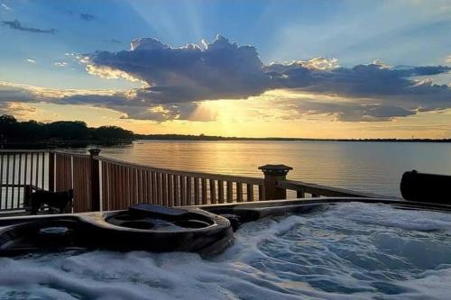 a hot tub on a deck with a view of the water at Lake Front Lake House Paradise! in Pittsburg