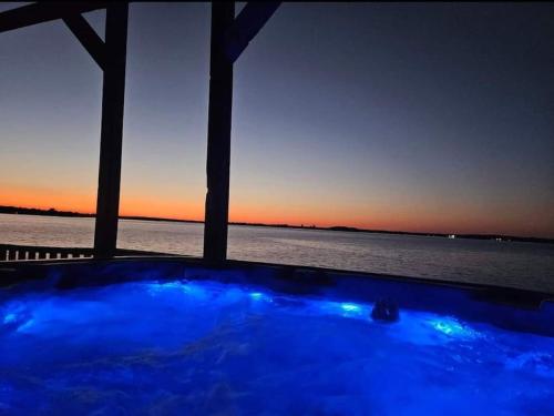a hot tub with a view of the water at sunset at Lake Front Lake House Paradise! in Pittsburg