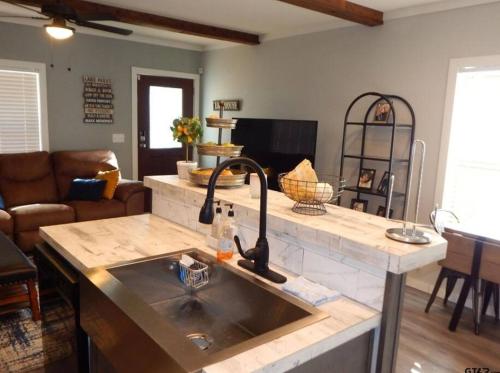 a kitchen with a sink and a living room at Lake Front Lake House Paradise! in Pittsburg