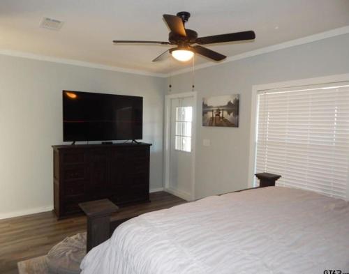 a bedroom with a bed and a ceiling fan at Lake Front Lake House Paradise! in Pittsburg