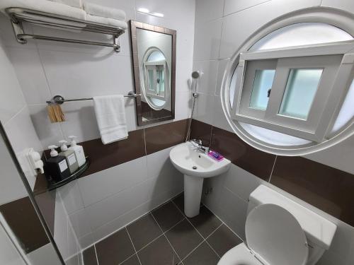 a bathroom with a sink and a toilet and a mirror at City Central & Cosy House in Gwangju