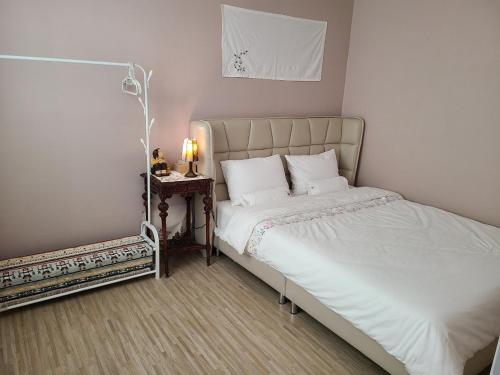 a bedroom with a bed and a side table at City Central & Cosy House in Gwangju