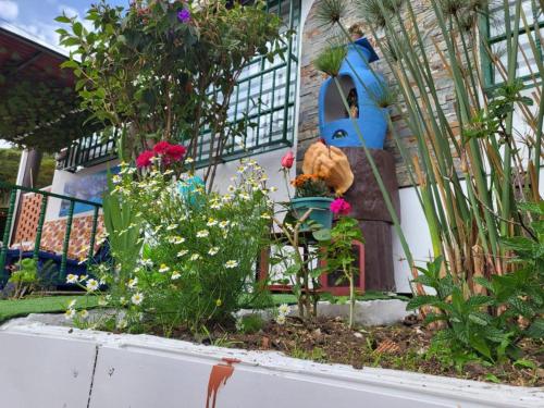 a garden with flowers in front of a house at Hotel Cerro Fuerte in Sopó