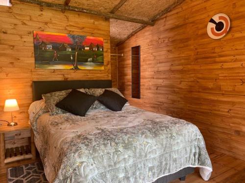 ein Schlafzimmer mit einem Bett in einer Holzwand in der Unterkunft Hotel Cerro Fuerte in Sopó