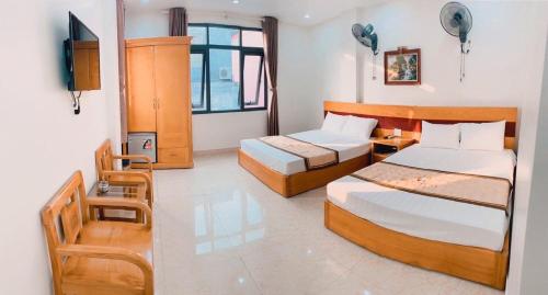 a hotel room with two beds and a television at Galaxy Home - Hotel Sky view in Cat Ba