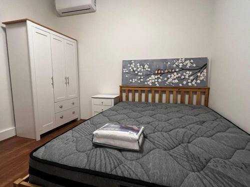 - une chambre avec un lit et une peinture murale dans l'établissement 3 Bedroom Cozy Stay 5km CBD, à Sydney