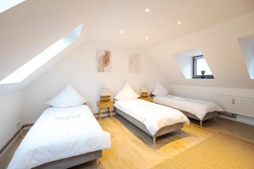 a attic bedroom with two beds and a window at 100qm - 3 rooms - central - RHM apartments in Hannover