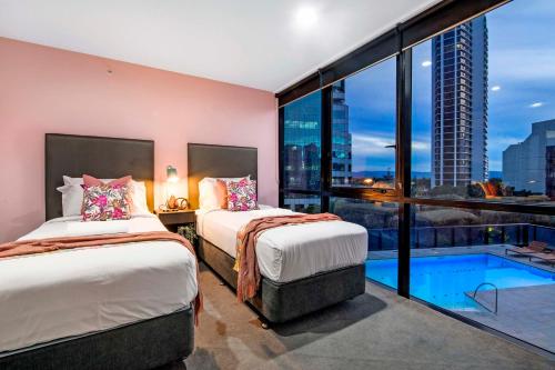 een slaapkamer met 2 bedden en een zwembad bij Pool View, Low Floor Apartment at Circle on Cavill - Wow Stay in Gold Coast