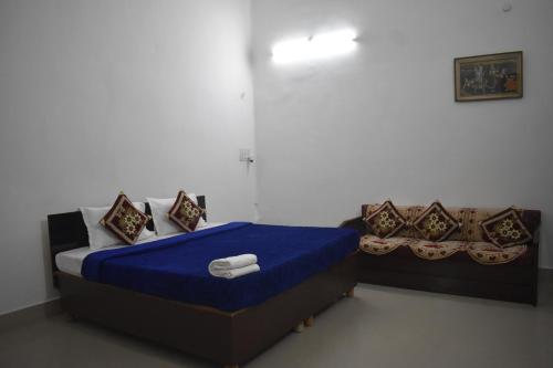 a bedroom with a bed with blue sheets and pillows at BAGEECHA VILLA in Allahābād
