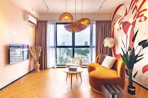 a living room with a yellow couch and a large window at Urban Suites, Signature Collection by Stellar ALV in Jelutong