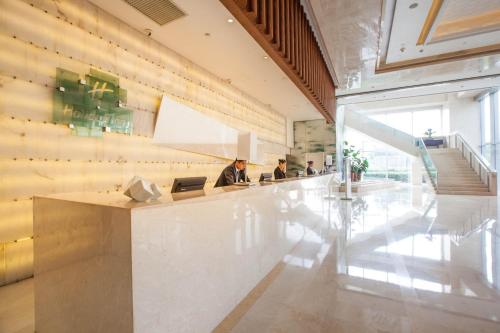 a lobby with two people sitting at a bar at Holiday Inn Beijing Focus Square by IHG in Beijing