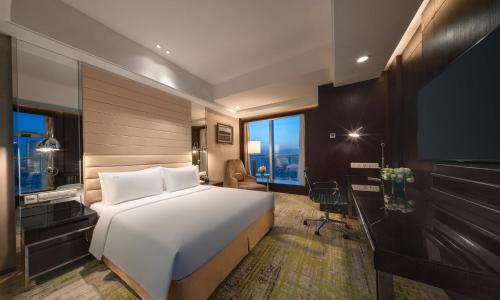a bedroom with a bed and a desk and a television at Holiday Inn Beijing Focus Square by IHG in Beijing