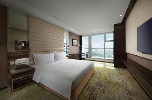 a bedroom with a large white bed and a flat screen tv at Holiday Inn Beijing Focus Square by IHG in Beijing