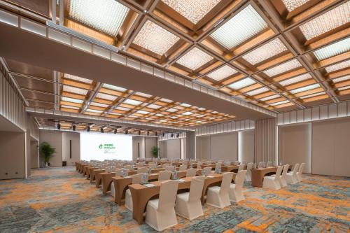 an empty hall with rows of chairs and a projection screen at Holiday Inn Beijing Focus Square by IHG in Beijing