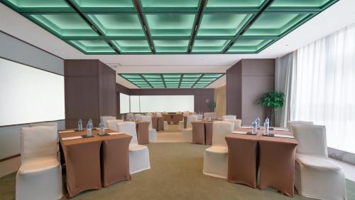 a room with tables and chairs and a room with a conference room at Holiday Inn Beijing Focus Square by IHG in Beijing