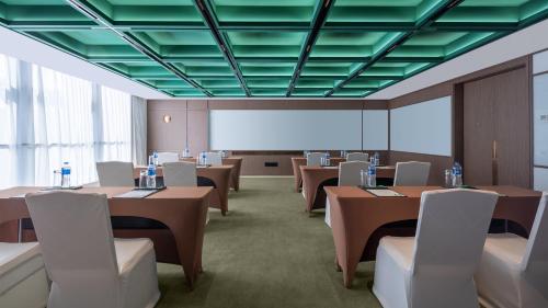 a conference room with tables and chairs and a whiteboard at Holiday Inn Beijing Focus Square by IHG in Beijing