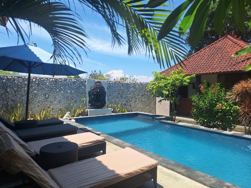 einen Pool mit Gartenmöbeln und einem Sonnenschirm in der Unterkunft D'Waktu in House in Nusa Lembongan