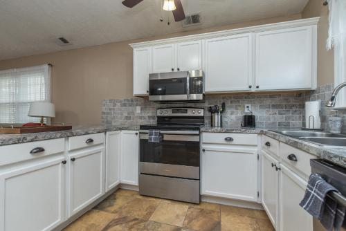 a kitchen with white cabinets and a stove top oven at Hamburg Haven Garage Fire Pit 7mi to Rupp WiFi in Lexington