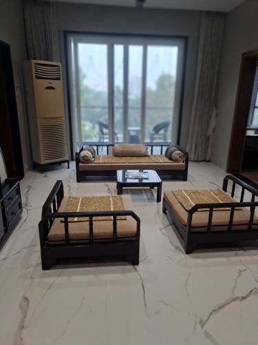three beds in a room with a large window at At par with 5 star hotel.. in Pune
