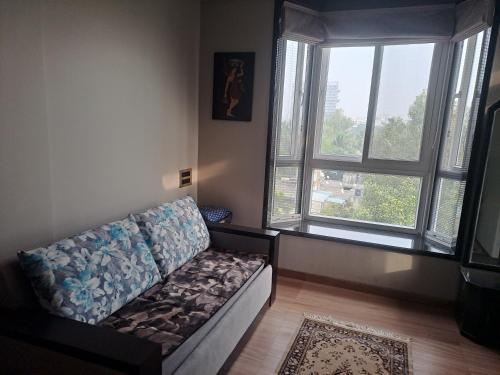 a living room with a couch and two windows at At par with 5 star hotel.. in Pune
