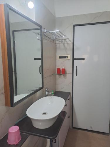 a bathroom with a sink and a large mirror at At par with 5 star hotel.. in Pune