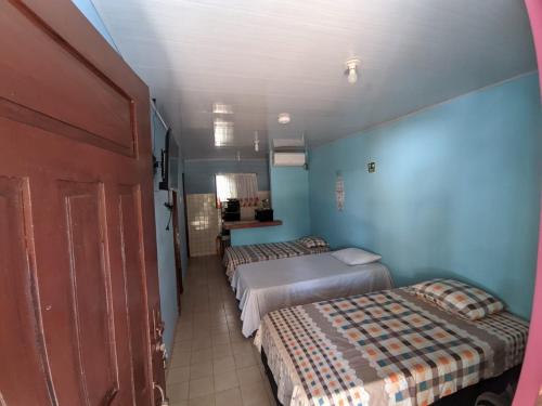 2 camas en una habitación con paredes azules en Bread Fruit Lodge en San Andrés